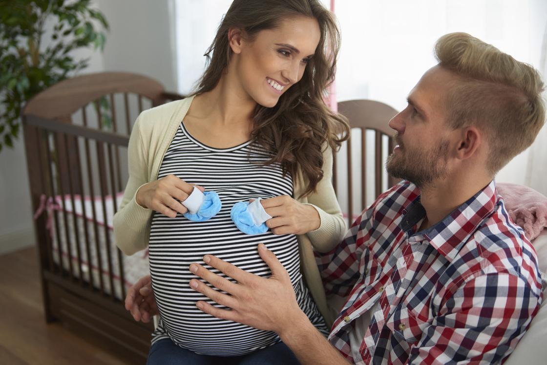 Чоловік обіймає вагітну дівчину Мужчина обнимает беременную девушку