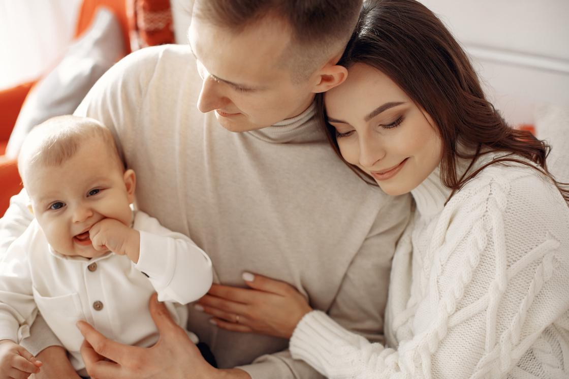 Батьки з дитиною на руках Родители с ребенком на руках