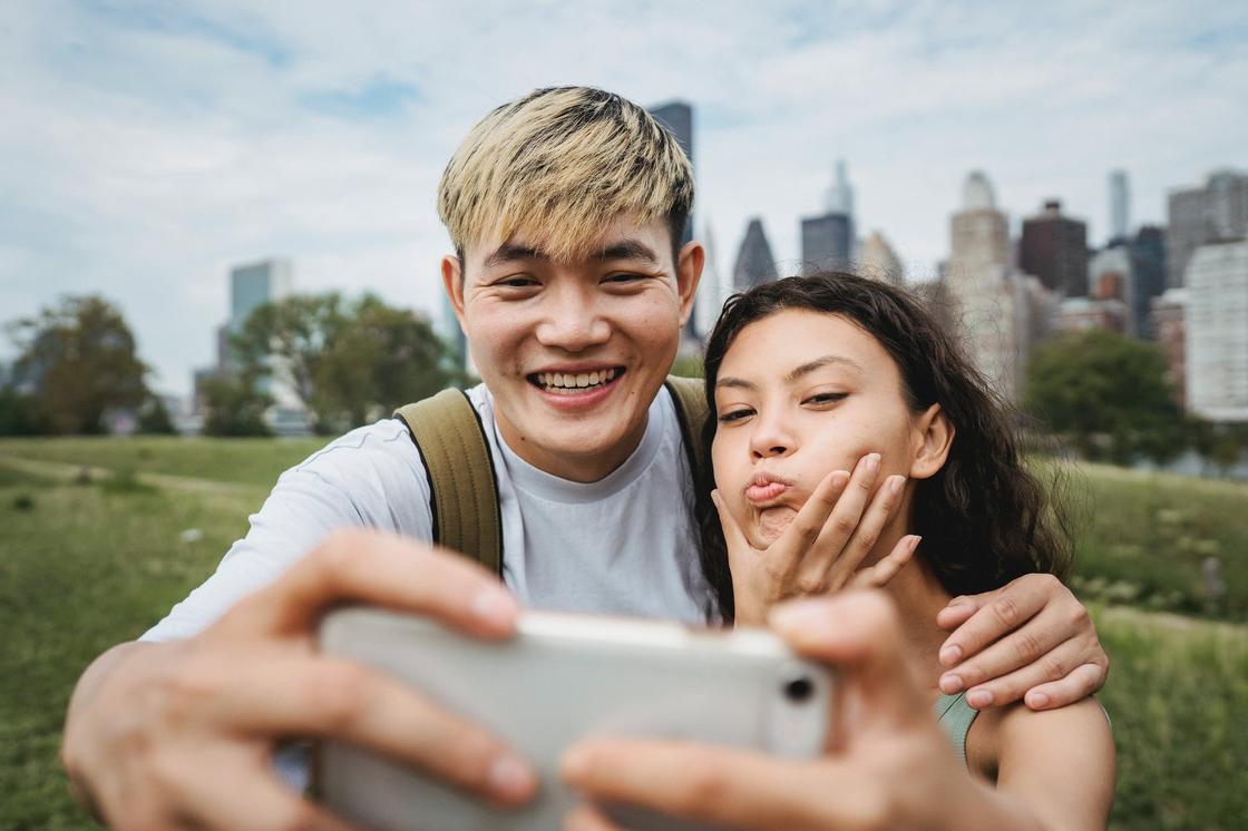 Хлопець і дівчина роблять selfie на тлі міста Парень и девушка делают селфи на фоне города