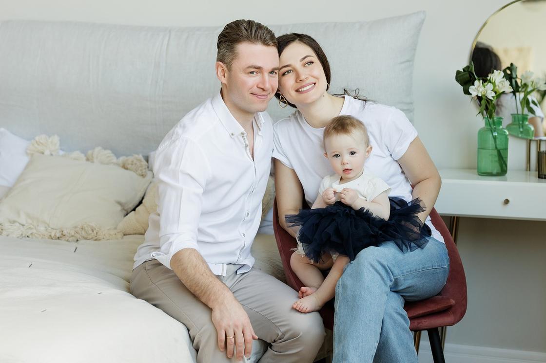 Батьки з дочкою сидять на дивані Родители с дочерью сидят на диване