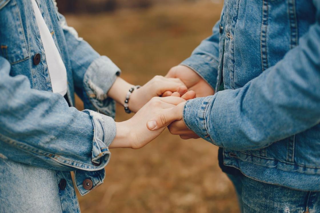 Хлопець тримає дівчину за руки Парень держит девушку за руки