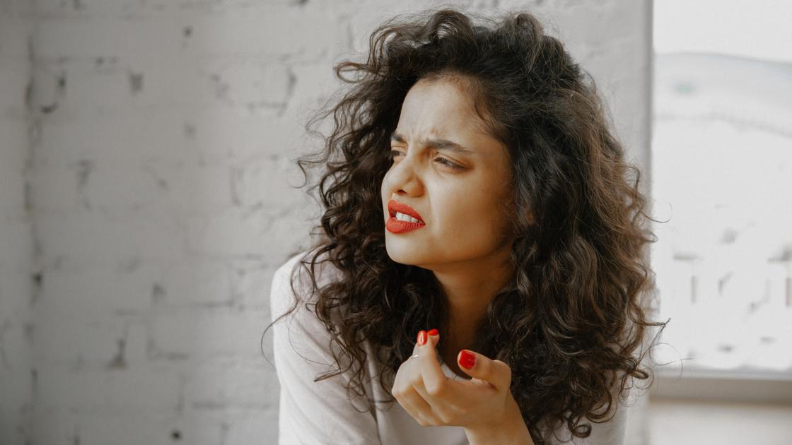 Жінка з червоною помадою та незадоволеним виразом обличчя Женщина с красной помадой и недовольным выражением лица