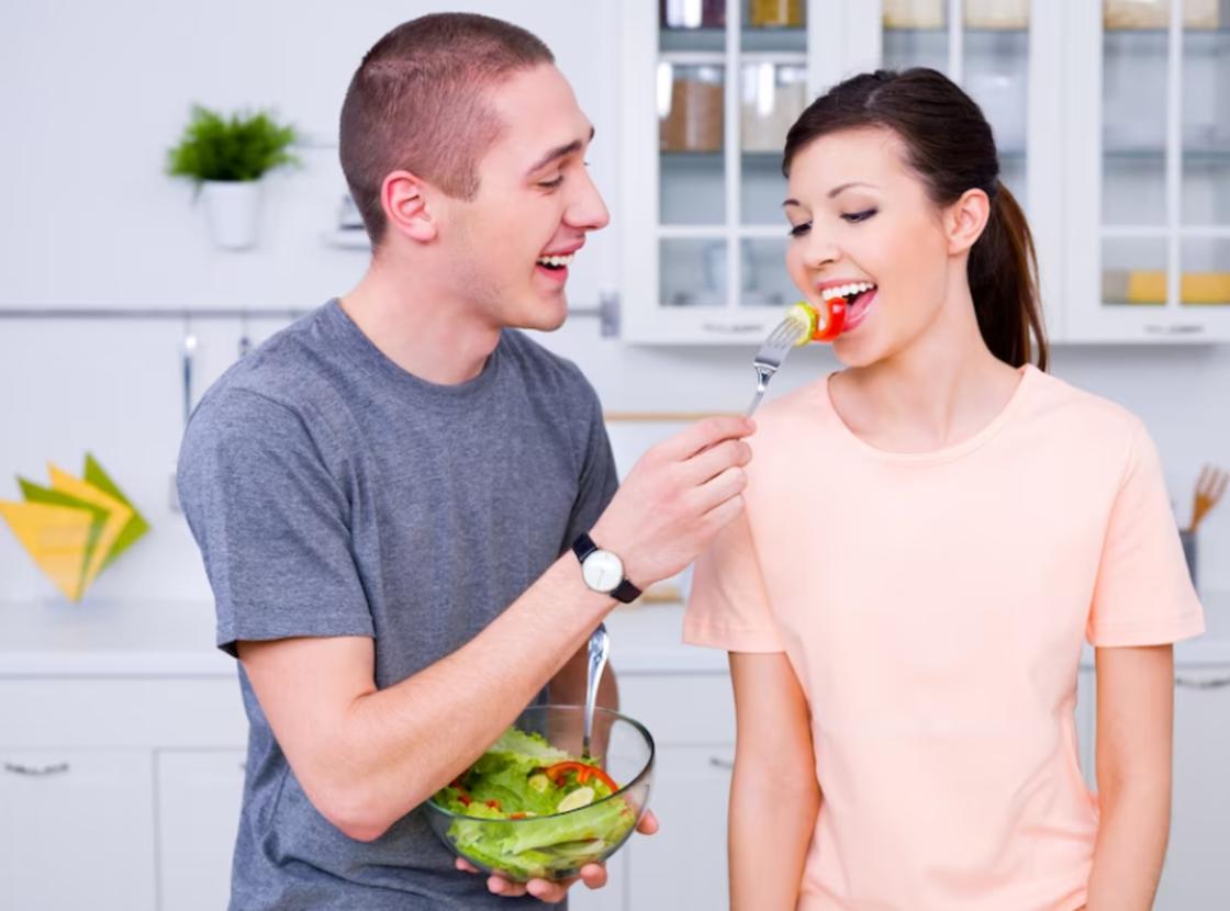 Хлопець годує дівчину салатом Парень кормит девушку салатом